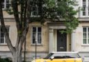 yellow mini cooper parked beside white concrete building