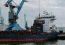 blue and red cargo ship with crane