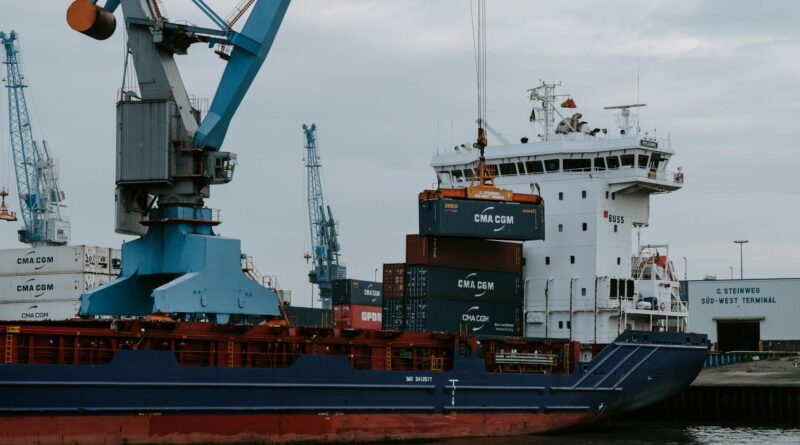 blue and red cargo ship with crane