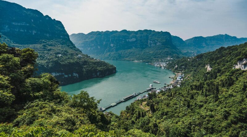photo of river near mountains covered with trees