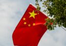 chinese national flag waving amongst trees outdoors